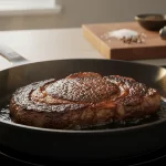 Rindersteak brät in Pfanne auf dem Herd.