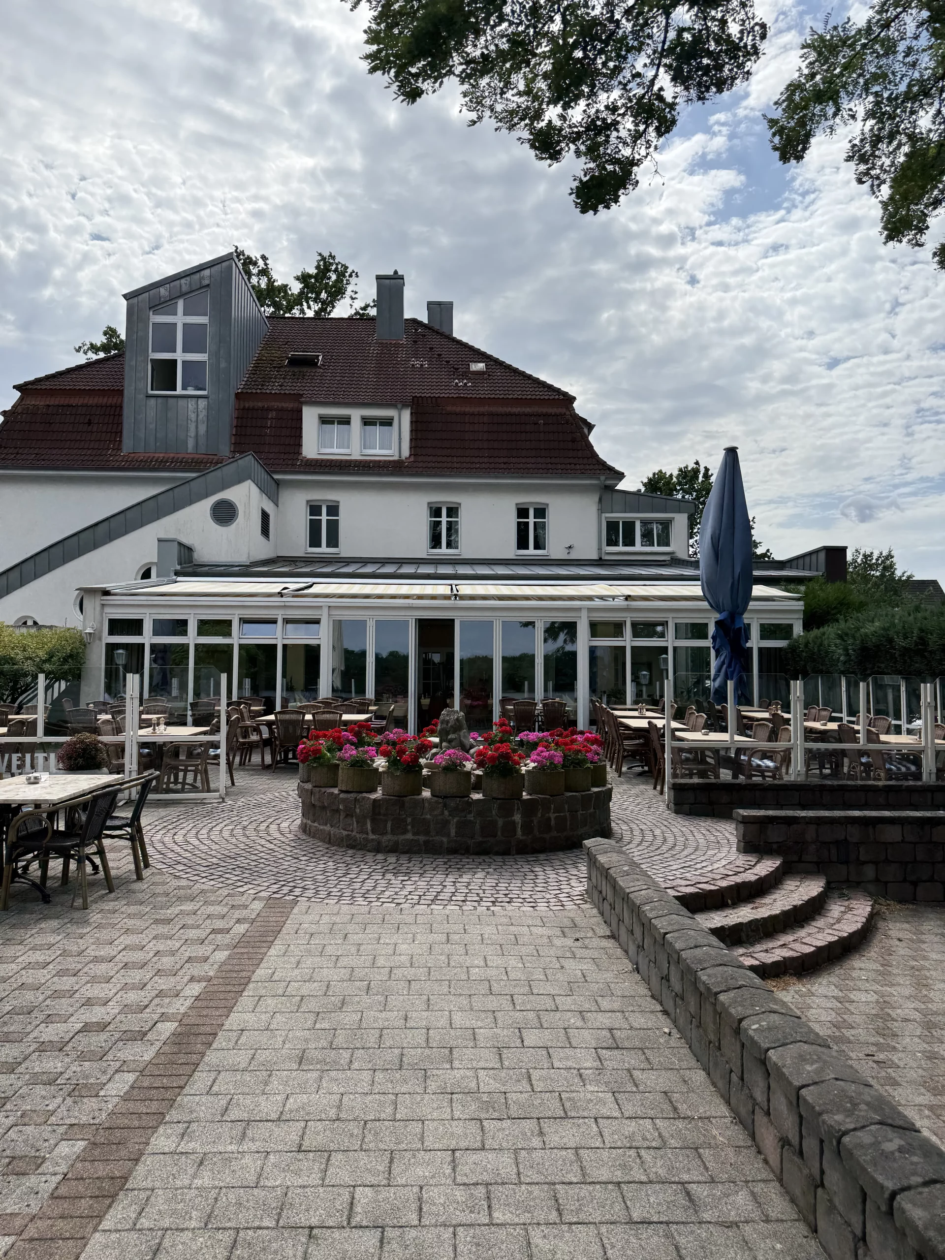 Terrassenrestaurant im Innenhof mit Blumenbeet.